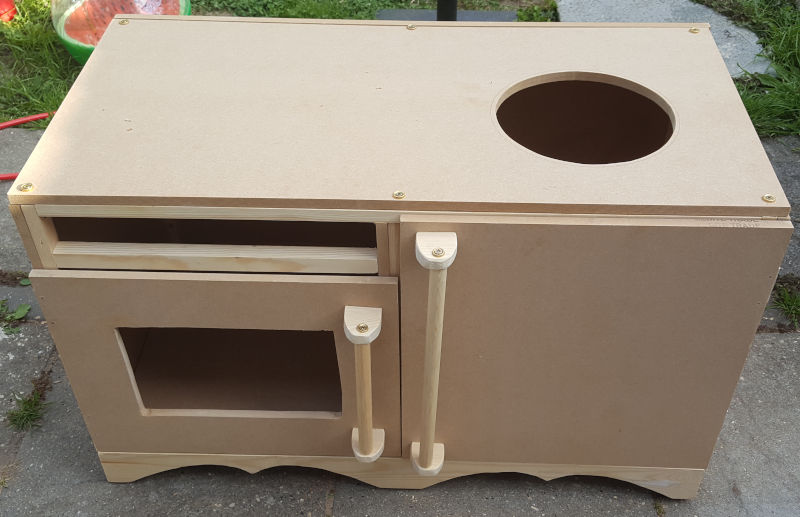 Unpainted woodwork complete showing top with hole cut for washing bowl, and handles added to doors